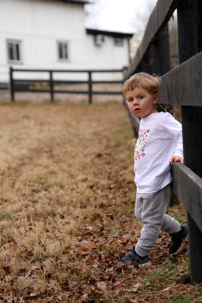 Young boy leaning on fence