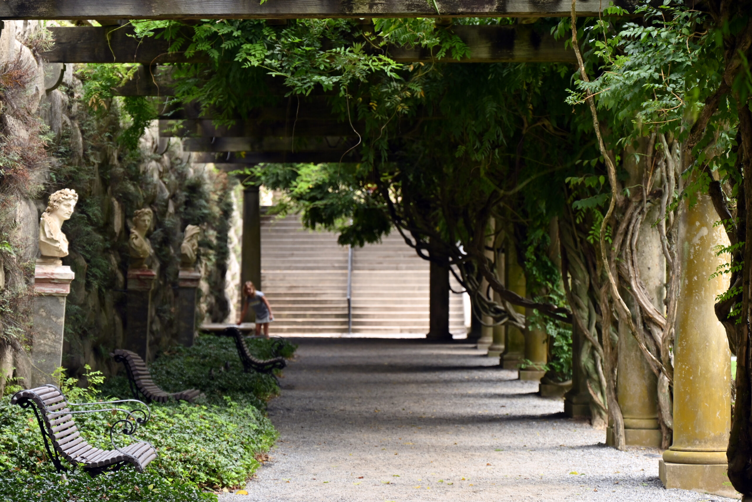 Little girl playing in the Ivy corridors of the Biltmore Estate in summer.